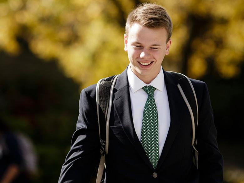 Student dressed in a suit on campus